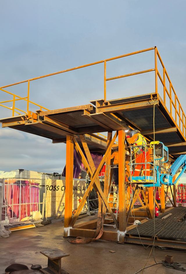 Fabricated yellow steel platform with handrails