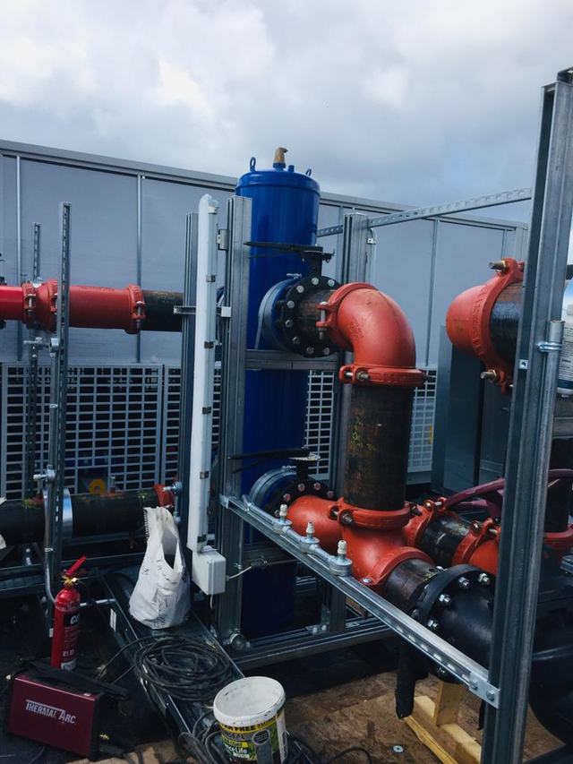 Red pipework and valves at a plant installation