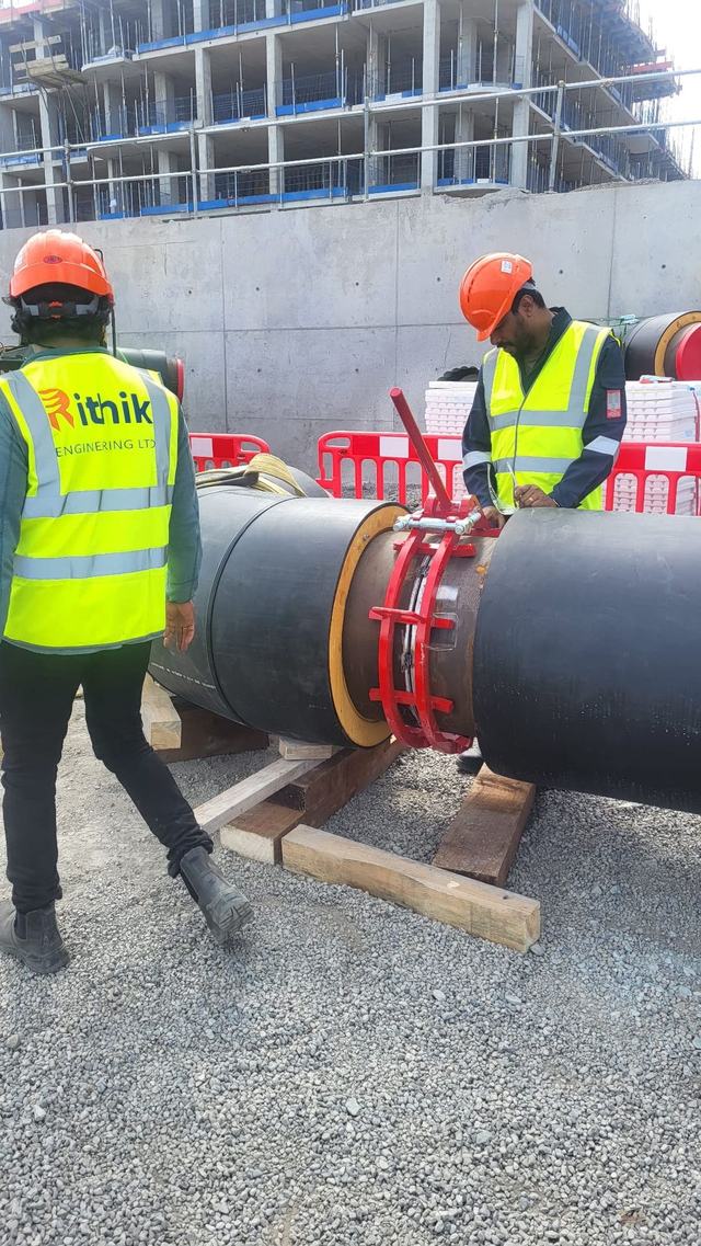 Rithik crew members fitting a pipe section on site
