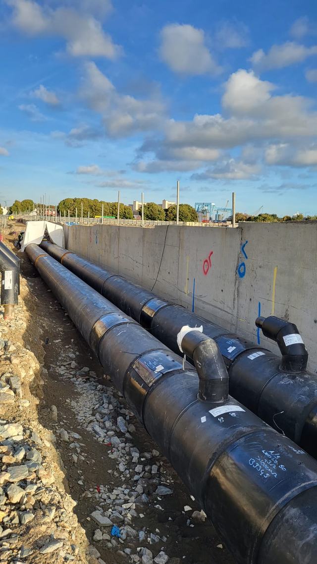 Pipeline laid in a trench alongside a concrete wall