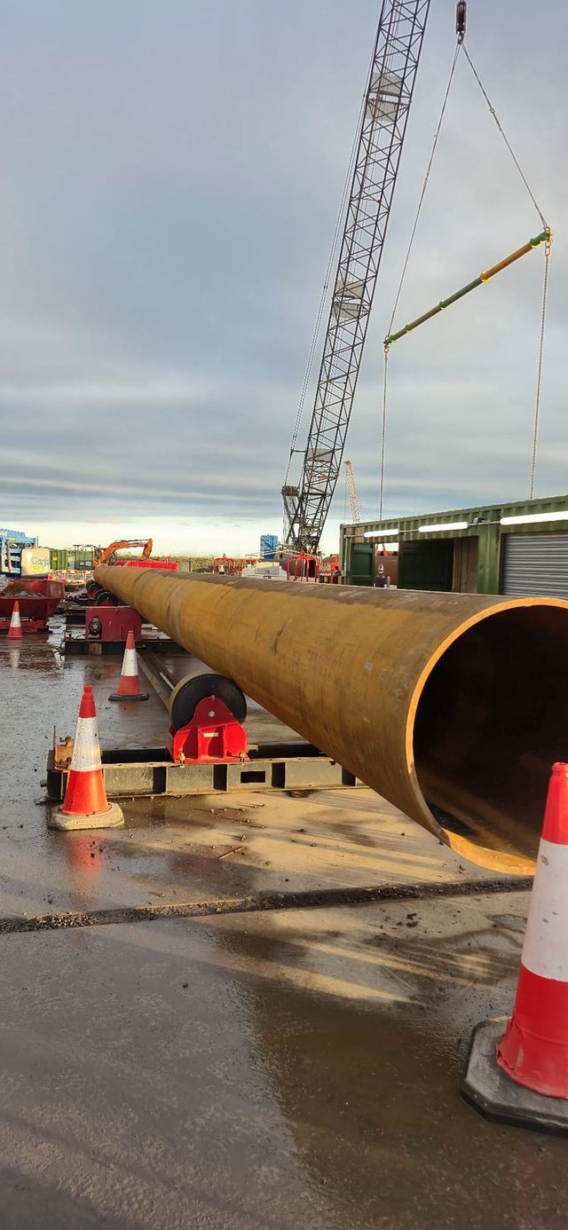 Large steel pipe lifted into position on site